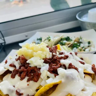 a plate of nachos with cheese and sauce