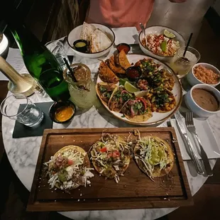 Taco flight, quesadilla, tostadas, elote, spicy pineapple margarita and lavender sour mocktail