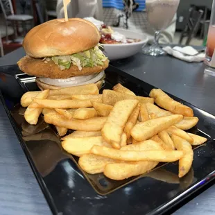 Crispy chicken sandwich without tomato with a side of fries.