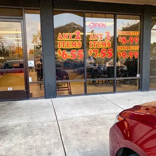 a red car parked in front of the restaurant