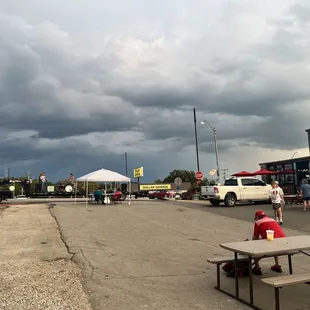 a parking lot with tables and umbrellas