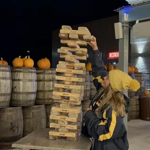a woman stacking wooden barrels
