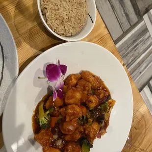 a plate of food with rice and a bowl of brown rice