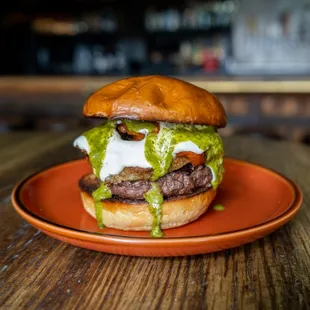 Caprese Burger with beef patty, roasted tomatoes, fried mozzarella, chimichurri, garlic aioli, brioche bun