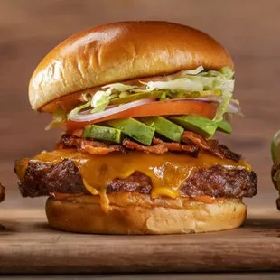three burgers on a cutting board