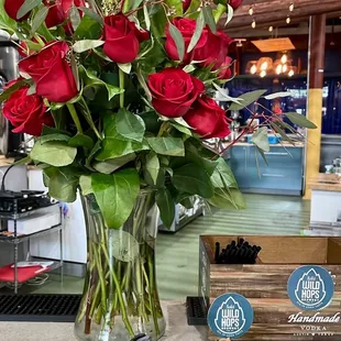 a vase of red roses and toy animals