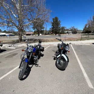 two motorcycles parked in a parking lot