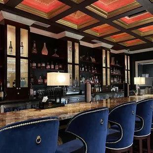 a bar with blue velvet chairs