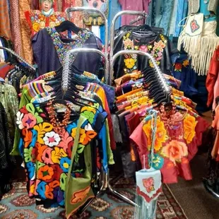 Hand embroidered blusas and Tehuanas huipiles from Mexíco. Top center, mauve colored lamb suede Xochit™ huipil.