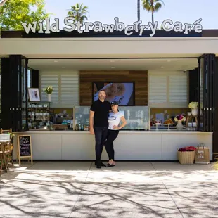 a man and woman standing in front of a stand