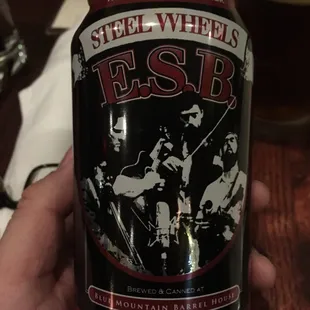 a person holding a can of beer