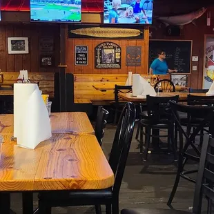 tables and chairs with a television in the background