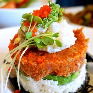 Creamy Scallop Tower: creamy scallop, crab, spicy tuna, avocado, masago, green onion layer-stacked with sushi rice. Lite spicy ($13).