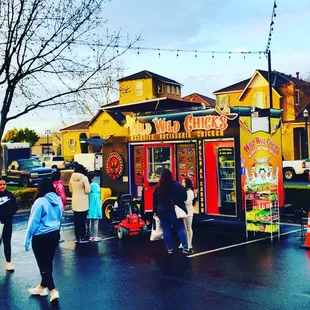 a food truck with people standing in front of it