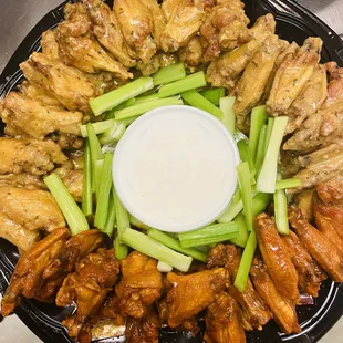 a platter of chicken wings and celery