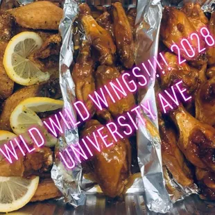 a tray of chicken wings with lemon slices