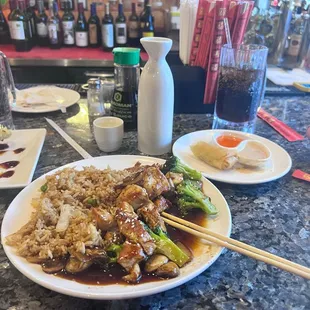 Chicken teriyaki hibachi with Pepsi and hot sake and a spring tool and steamed dumplings