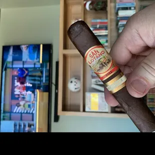 a hand holding a cigar