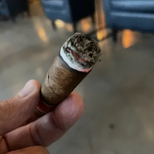 a hand holding a cigar