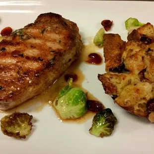 French cut Pork Chop grilled and served with a savory herb pan jus, Sausage Bread Pudding, roasted Brussels Sprouts and craisin.