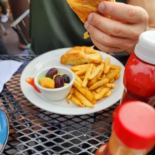 a person eating a sandwich and french fries