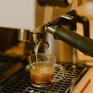 a coffee being poured into a cup