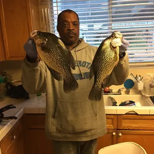 a man holding two fish