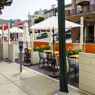 New outdoor parklets with barriers between tables and semi-private booths