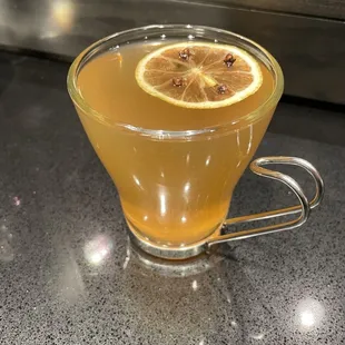 a glass cup of wildwood tea with a slice of lemon