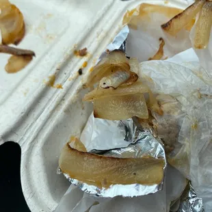 a partially eaten food item in a styrofoam container