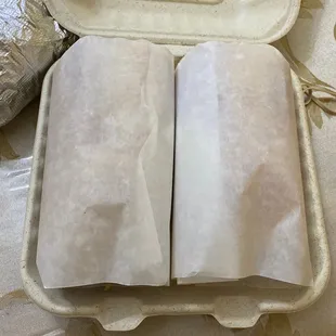 two burritos in a paper container