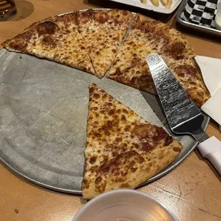 a pizza on a pizza pan with a slice taken out of it