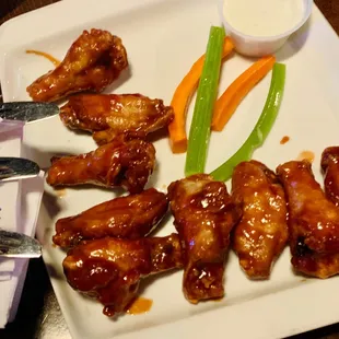 a plate of chicken wings and carrots