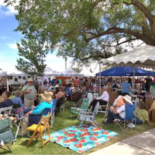 a large group of people sitting under tents