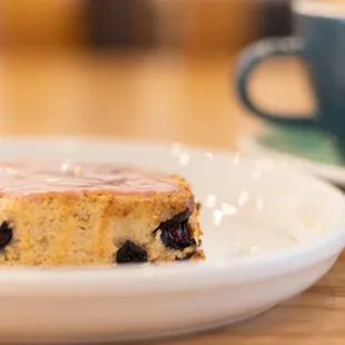 a piece of cake on a plate next to a cup of coffee