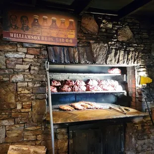 ows a man standing in front of a brick oven