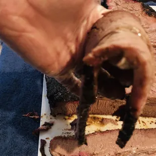 a hand holding a piece of meat