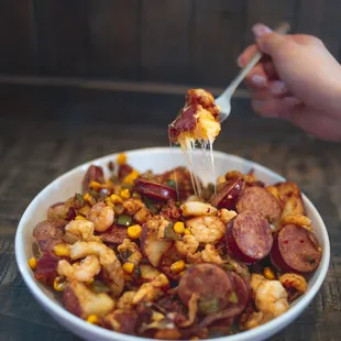 LEFTOVER HASH: Crispy hash browns with melted Monterey Jack and Cheddar cheese, smoked sausage, sautéed shrimp, crawfish tails, corn, onions