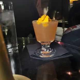 a glass with a drink on a table