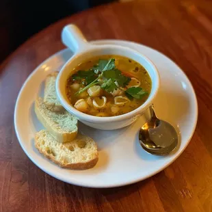 a bowl of soup and bread on a plate