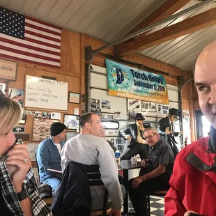 a man in a red jacket eating a hot dog