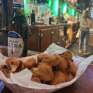 a basket of fried food and a bottle of beer