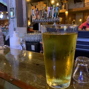 a glass of beer on a bar