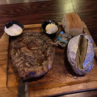 a steak and bread on a cutting board
