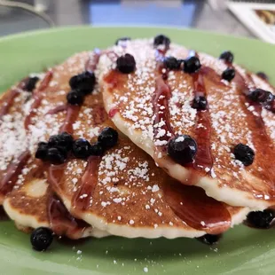 a stack of pancakes on a green plate