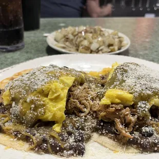 Shredded pork and eggs and beans over tortillas.