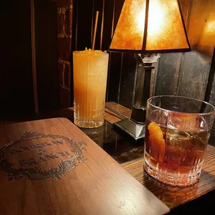 a table with a drink and a lamp