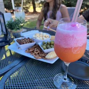 a glass of wine and a plate of snacks