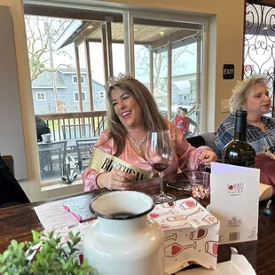 two women sitting at a table with wine glasses
