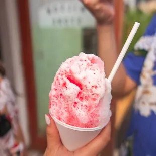a person holding a cup of ice cream